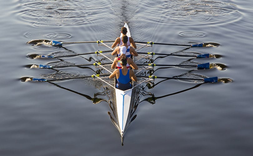 Crew team rowing a race boat on a river